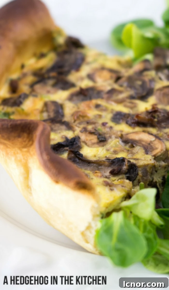 A beautifully baked cheesy mushroom quiche with a golden crust, displayed in a rustic kitchen setting. #quicherecipes