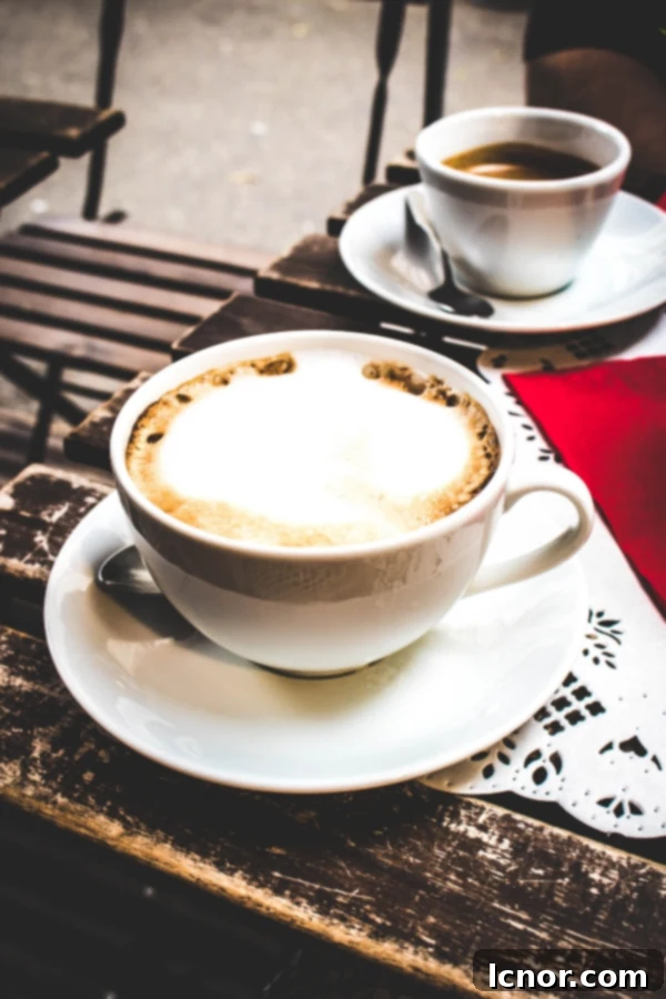 A cup of coffee next to East German Pastries at Kaffeehaus Paris