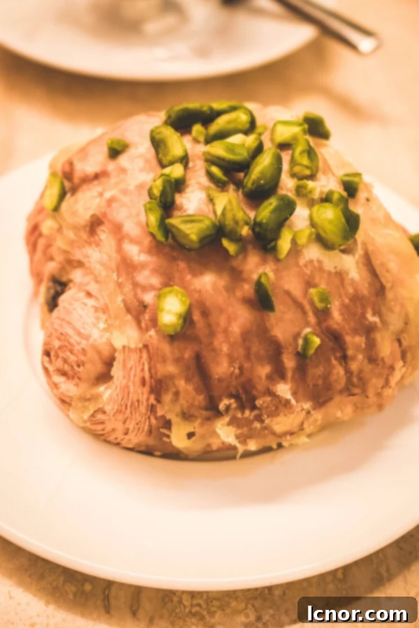 Croissant topped with vibrant green pistachios, a delightful pastry available at 86 Champs