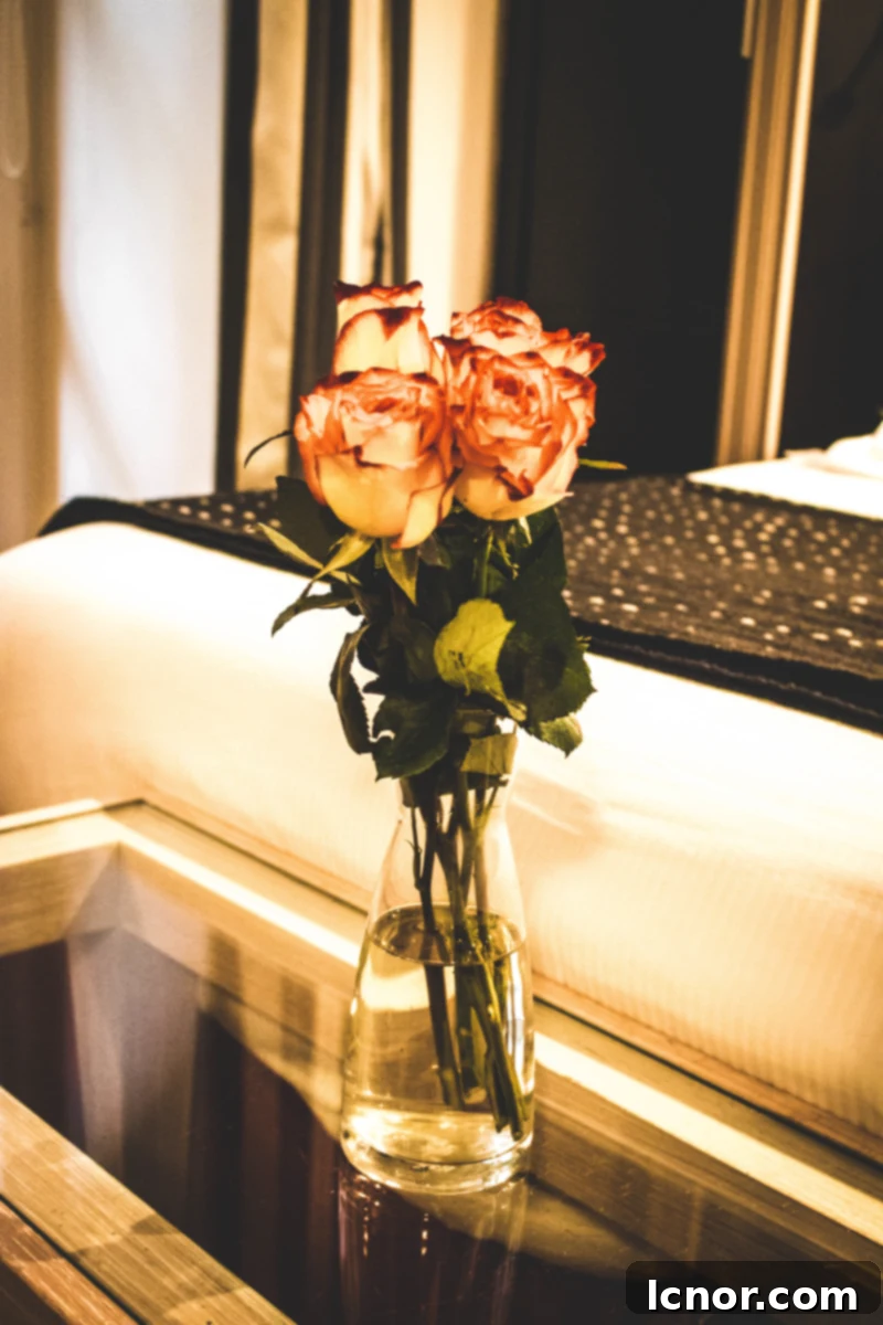 Magazine and fresh flowers on a bedside table at Hotel du Jeu de Paume, Paris.