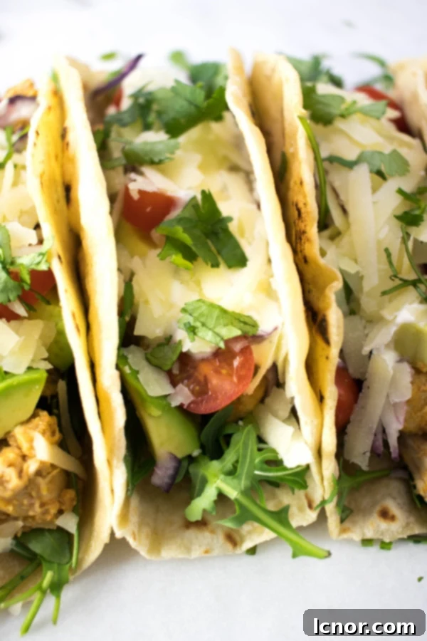 Sour cream, beyaz, kırmızı ve yeşil soslarla süslenmiş, tavukla doldurulmuş birkaç yumuşak taco