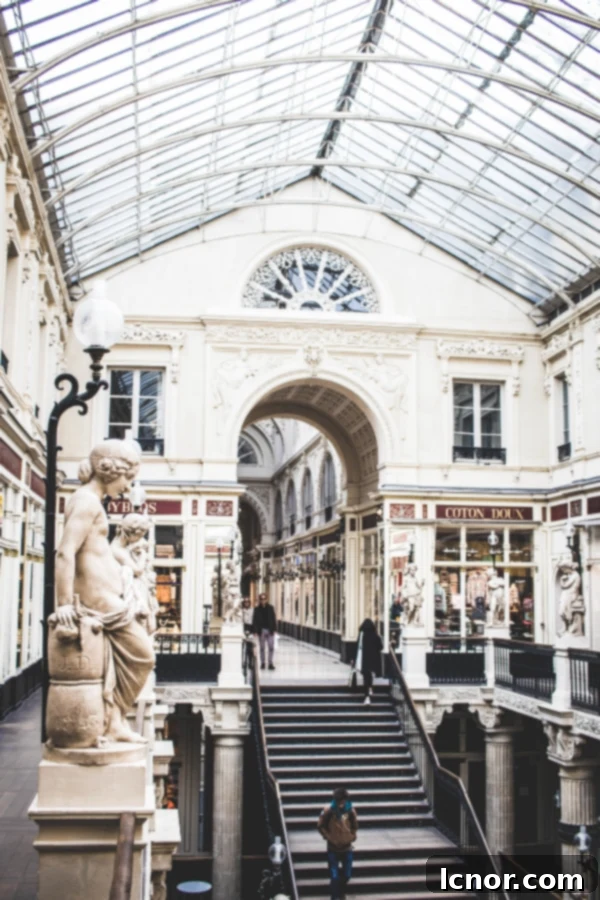 White passage arcade with shop windows and statues