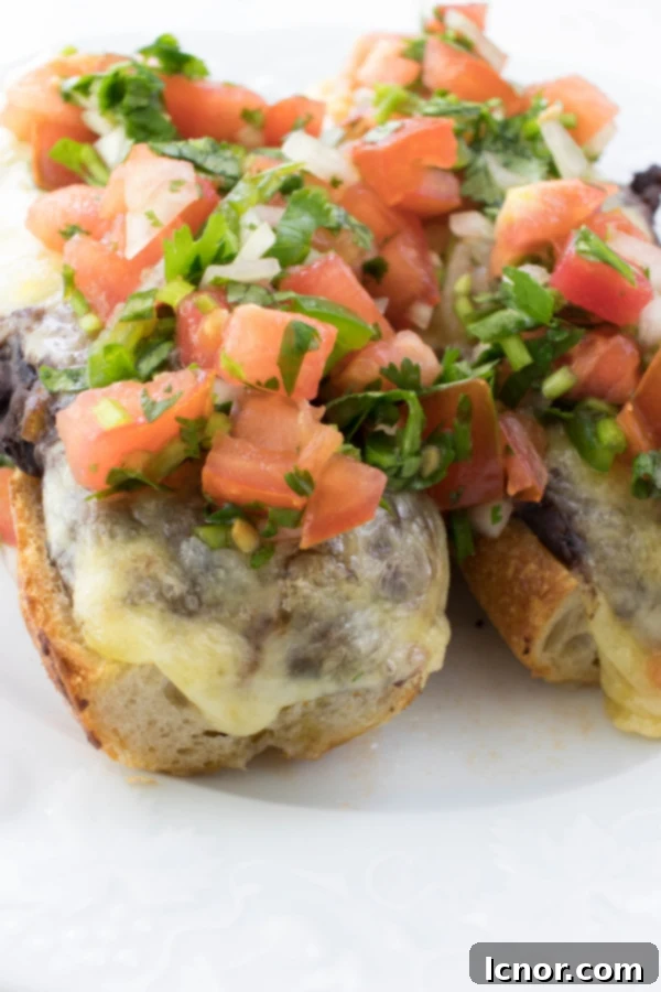 Delicious Cheesy Mexican Molletes 4 front facing cheese sandwich topped with tomatoes and cilantro