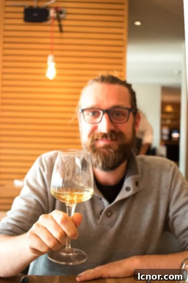 man holding a glass of white wine