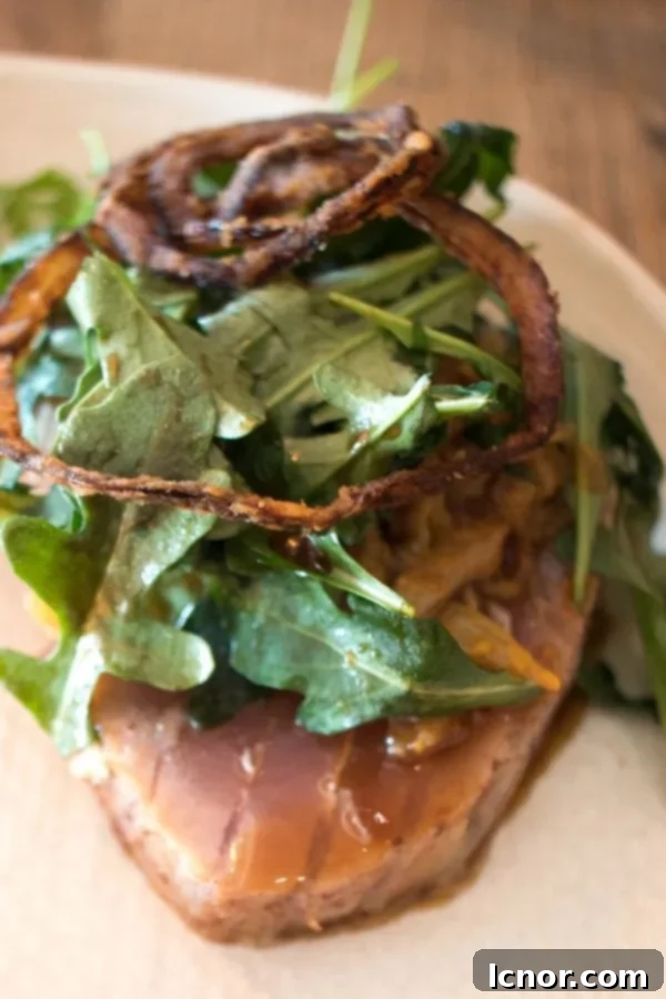tuna steak topped with lettuce and onions