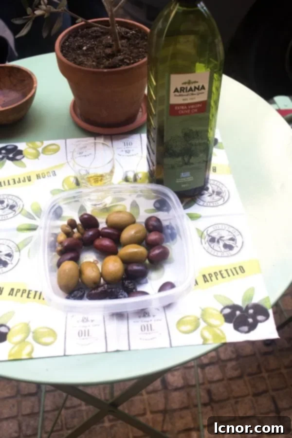 A variety of Greek olives - Athens food at its finest. A bottle of Greek olive oil and an olive tree.