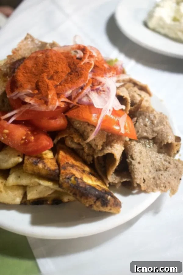 Greek gyro - open faced pita topped with sliced meat and vegetables, the perfect Athens food.