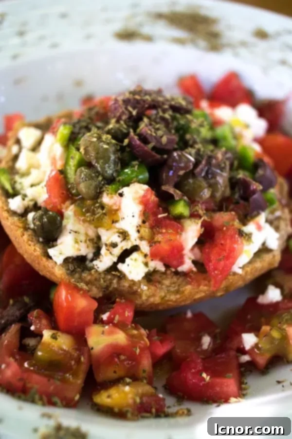 Toasted bread salad topped with vegetables and Greek feta cheese.