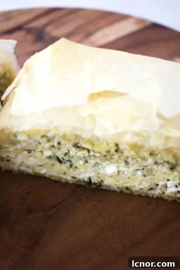 Tiropita (Greek Cheese Pie) - a close-up photo on a wooden cutting board, showing the texture and deliciousness.