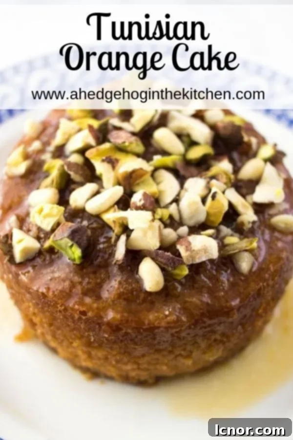 Pinterest pin featuring a whole Tunisian orange cake adorned with nuts and citrus glaze, ready for serving.
